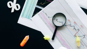Лупа над документами как иллюстрация проверки контрактов CFTC